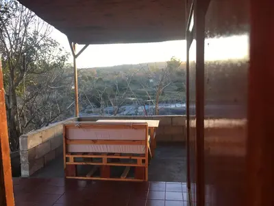 a screened in porch with a bench and a view at Sol de Bach in Tanti