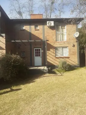 a brick house with a white door and a yard at al pie del morro in Merlo