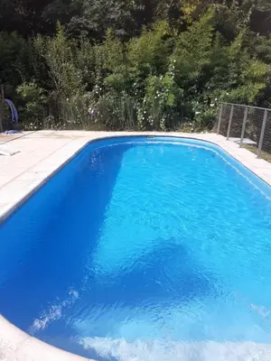 a large blue swimming pool in a yard at al pie del morro in Merlo