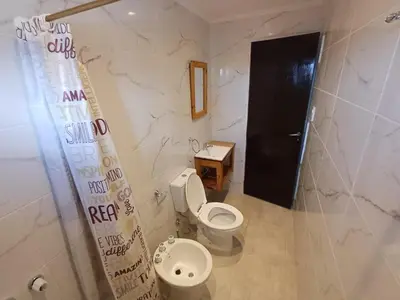 a bathroom with a toilet and a black door at La Villa Inn in Villa Carlos Paz