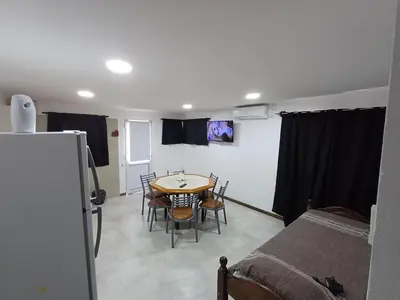a room with a table and chairs and a bed at La Villa Inn in Villa Carlos Paz