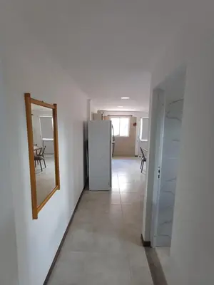 a hallway with a mirror and a refrigerator at La Villa Inn in Villa Carlos Paz