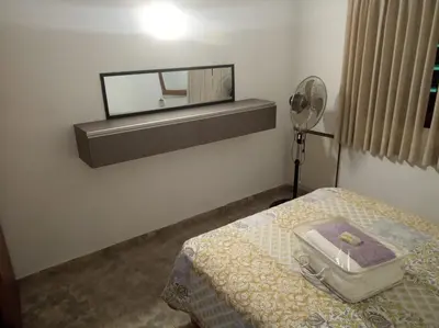 a room with a bed with a mirror on the wall at Casa en Santa Rosa de Calamuchita in Santa Rosa de Calamuchita