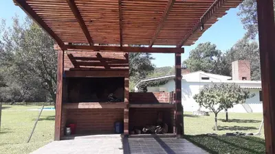 a wooden pergola with two dogs laying in it at Casa en Santa Rosa de Calamuchita in Santa Rosa de Calamuchita