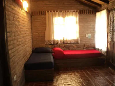 a room with two beds and a window at Cabanas en el Jardin Nativo in San Francisco del Monte de Oro
