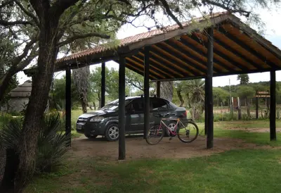 a car parked under a pavilion with a bike under it at Cabanas en el Jardin Nativo in San Francisco del Monte de Oro
