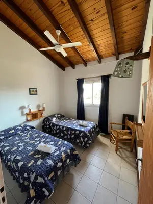 a bedroom with two beds and a wooden ceiling at Entre Sierras in Villa General Belgrano