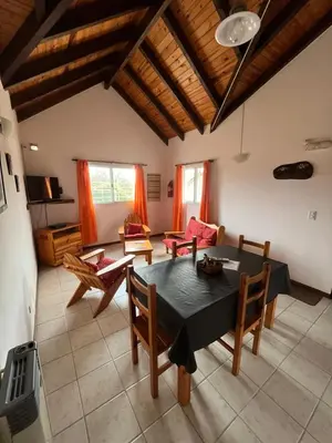 a living room with a dining room table and chairs at Entre Sierras in Villa General Belgrano