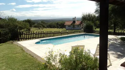 a swimming pool in a yard with a fence at Entre Sierras in Villa General Belgrano