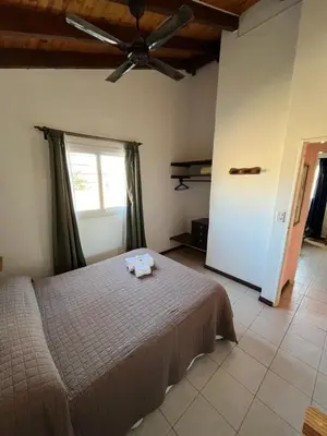 a bedroom with a bed and a ceiling fan at Entre Sierras in Villa General Belgrano