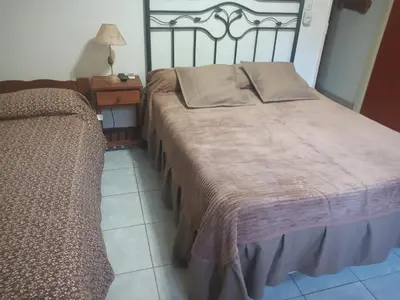 a bedroom with a bed and a table with a lamp at Complejo ARABELA in Merlo