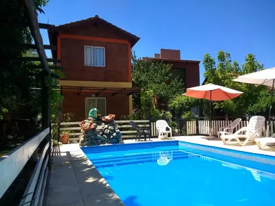 a swimming pool in front of a house at Complejo ARABELA in Merlo
