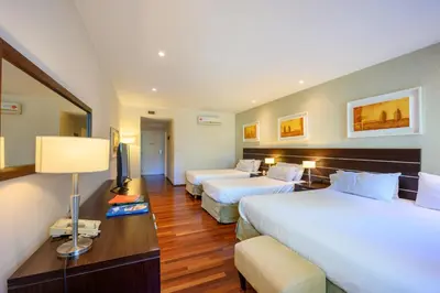 a hotel room with two beds and a television at Orfeo Suites Cordoba in Cordoba