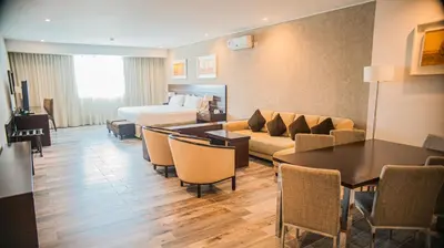 a hotel room with a bed and a couch and a table at Orfeo Suites Cordoba in Cordoba