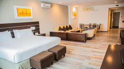 a hotel room with a bed and a living room at Orfeo Suites Cordoba in Cordoba