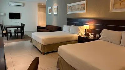 a hotel room with two beds and a living room at Orfeo Suites Cordoba in Cordoba