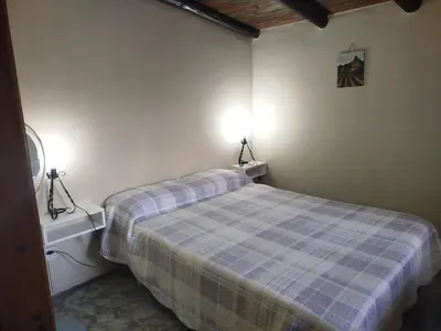 a bedroom with a bed and two lights on the wall at Departamento Manna in Alta Gracia