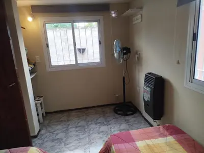 a room with a bed and a window and a television at Departamento Manna in Alta Gracia