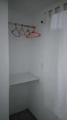 a white room with red hangers on a wall at Departamento Manna in Alta Gracia