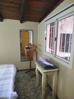 a bedroom with a bed and a table and a mirror at Departamento Manna in Alta Gracia
