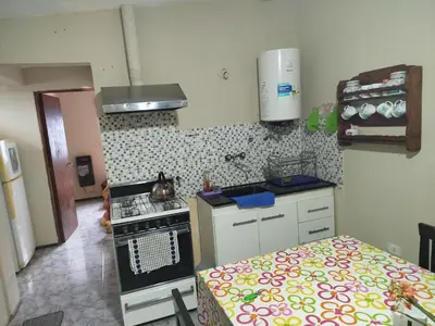 a small kitchen with a stove and a bed at Departamento Manna in Alta Gracia