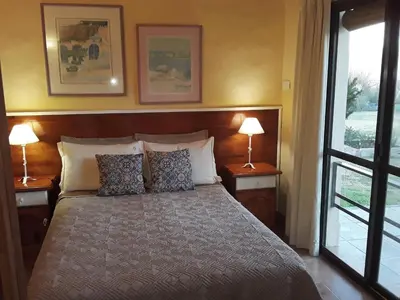 a bedroom with a bed with two lamps and a window at Cabanas Vista Hermosa in Santa Rosa de Calamuchita