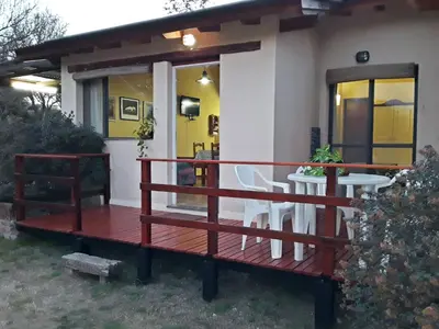 a porch of a house with a table and chairs at Cabanas Vista Hermosa in Santa Rosa de Calamuchita