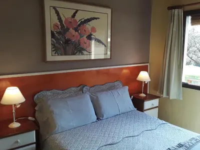 a bedroom with a bed with blue pillows and two lamps at Cabanas Vista Hermosa in Santa Rosa de Calamuchita