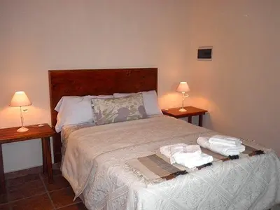 a bedroom with a bed with two lamps on two tables at Cabanas Vista Hermosa in Santa Rosa de Calamuchita