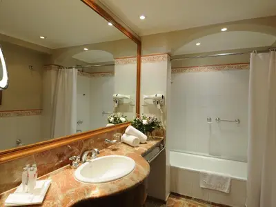 a bathroom with a sink and a tub and a mirror at Windsor Hotel in Cordoba