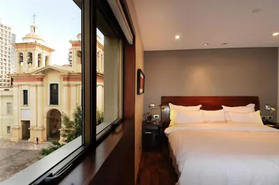 a bedroom with a bed and a large window at Windsor Hotel in Cordoba