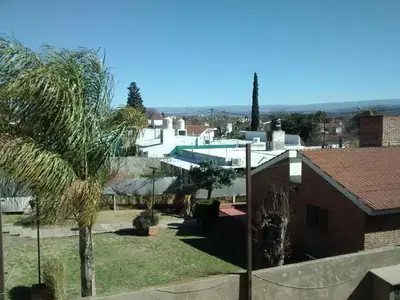 a view of a house with a palm tree at Complejo Camila in Villa Carlos Paz