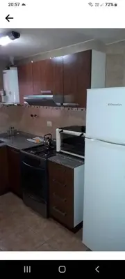 a kitchen with a stove and a refrigerator at Complejo Camila in Villa Carlos Paz