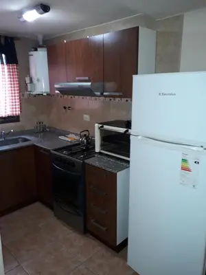 a kitchen with a stove and a refrigerator at Complejo Camila in Villa Carlos Paz