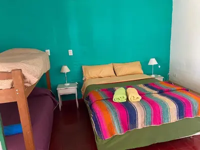 a bedroom with a bed with two slippers on it at La Casa de Don Pepe in Villa de Las Rosas
