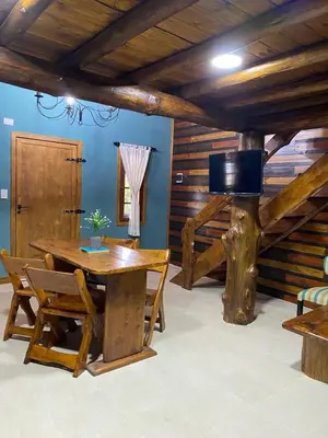 a dining room with a wooden table and chairs at Suenos del Bosque ApartHotel in Atos Pampa