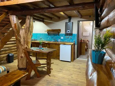 a kitchen with a table and a white refrigerator at Suenos del Bosque ApartHotel in Atos Pampa