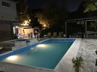 a swimming pool in a backyard at night at Robinson Apartamentos SOLO FAMILIAS in Villa Carlos Paz
