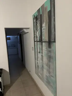a hallway with paintings hanging on a wall at Robinson Apartamentos SOLO FAMILIAS in Villa Carlos Paz