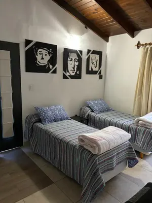 two beds in a room with pictures on the wall at Robinson Apartamentos SOLO FAMILIAS in Villa Carlos Paz