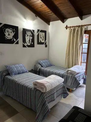 two beds in a room with pictures on the wall at Robinson Apartamentos SOLO FAMILIAS in Villa Carlos Paz