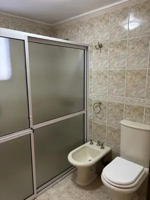 a bathroom with a shower and a toilet and a sink at Robinson Apartamentos SOLO FAMILIAS in Villa Carlos Paz