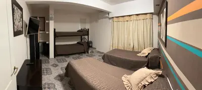 a small bedroom with two beds and a television at Robinson Apartamentos SOLO FAMILIAS in Villa Carlos Paz