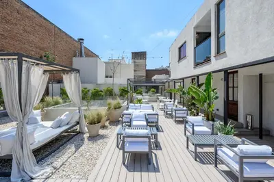 a patio with lounge chairs and tables on a building at Azur Hotel & Spa in Cordoba