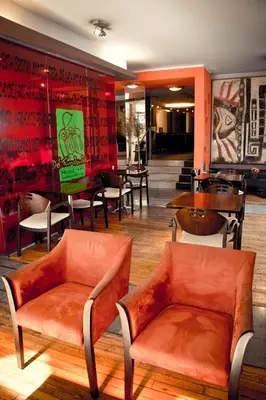 a restaurant with orange chairs and tables in a lobby at Del Fundador in Cordoba