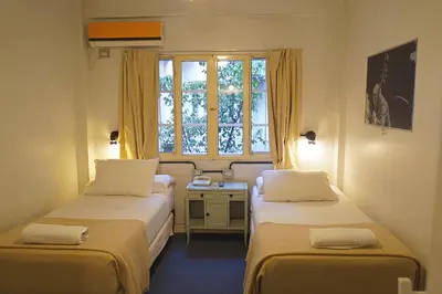 two beds in a small room with a window at Casa Urbana Hotel in Cordoba
