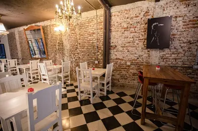 a restaurant with white chairs and tables and a chandelier at Casa Urbana Hotel in Cordoba