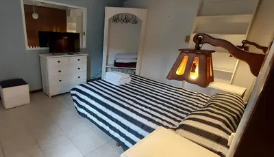 a small bedroom with a bed and a lamp at Merlo 1 in Merlo