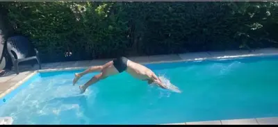 a man swimming in a swimming pool with a dolphin at Merlo 1 in Merlo