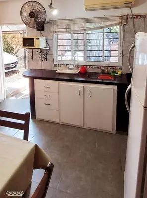 a kitchen with white cabinets and a black counter top at Merlo 1 in Merlo